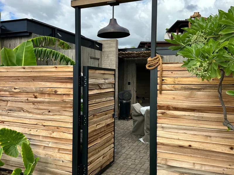 Custom metal-framed entry gate with wood panels, Maui